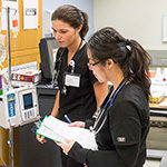 Two nursing students consult on a case.