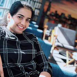 Anusree Poduval sitting on a couch.