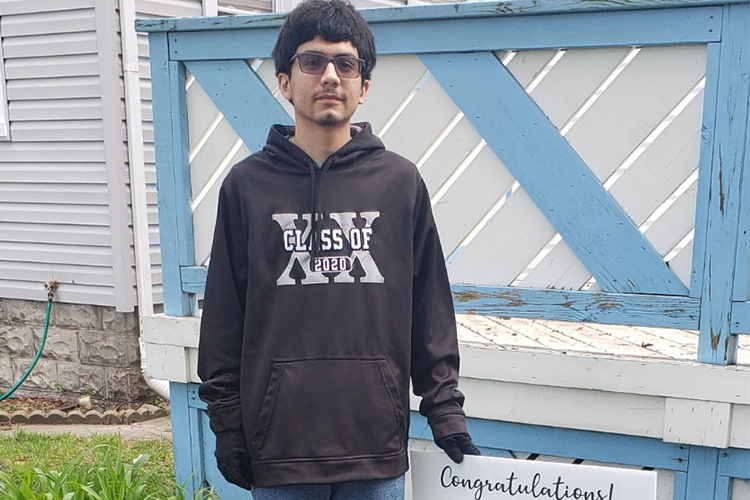 Romulo Gutierrez poses with a congratulatory sign presented to him from Purdue Northwest’s Concurrent Enrollment Program representatives.