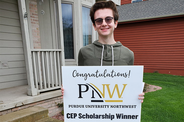 Benjamin Hand holds his personally delivered congratulatory sign received from Purdue Northwest’s Concurrent Enrollment Program representatives.