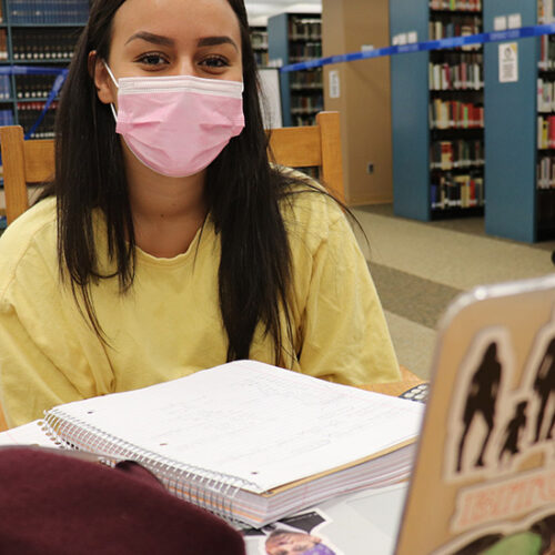 A PNW student wears a mask in the Westville library
