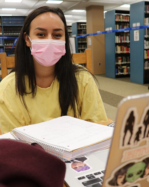 A PNW student wears a mask in the Westville library