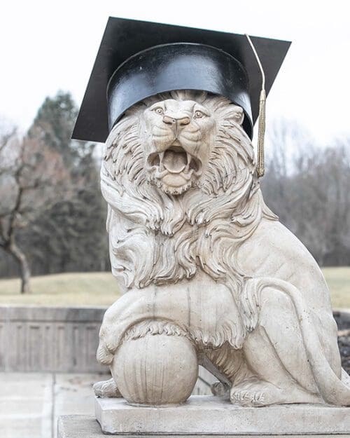 A PNW Lion Sculpture wearing a commencement cap