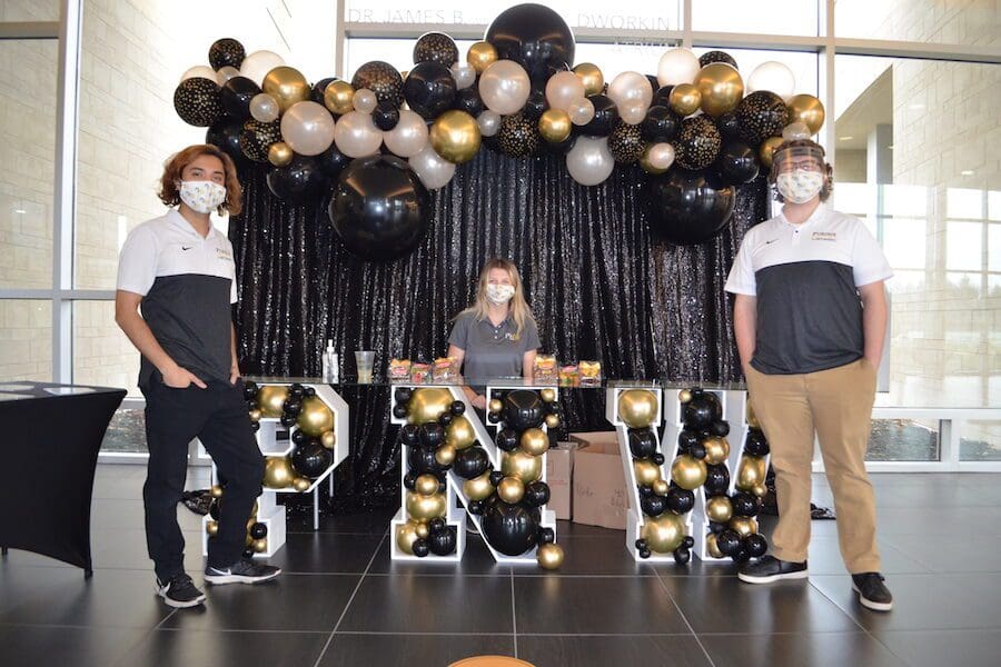 Students standing in front of PNW swag.