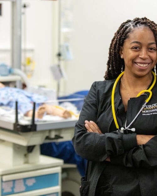 PNW student stands within the Robert J. Milos, M.D. & Margaret J. Milos, R.N. Nursing Assessment Center.