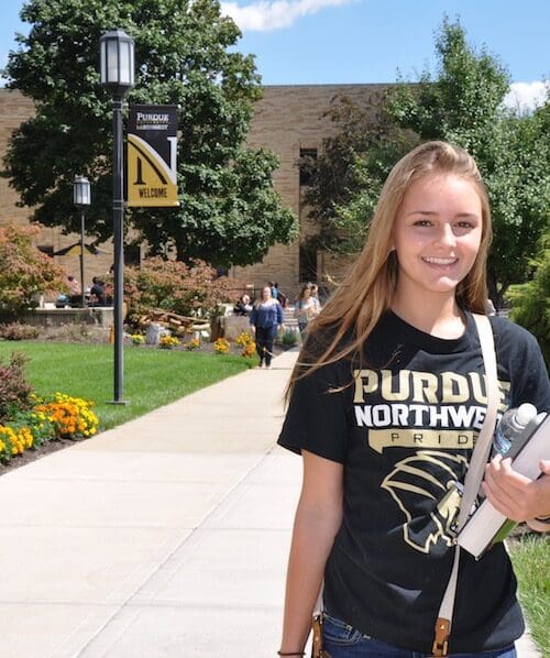 A student is smiling on campus.