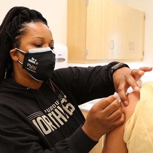 A student is vaccinated for COVID-19 at a PNW vaccination clinic.