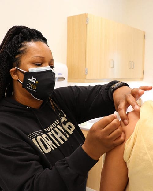 A student is vaccinated for COVID-19 at a PNW vaccination clinic.