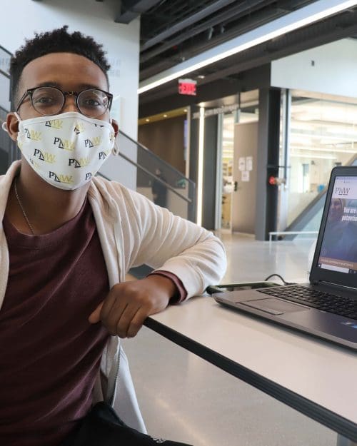 Purdue Northwest senior Gerald Akujobi volunteers at check-in during a COVID-19 vaccination clinic at the Nils K. Nelson Bioscience Innovation Building.