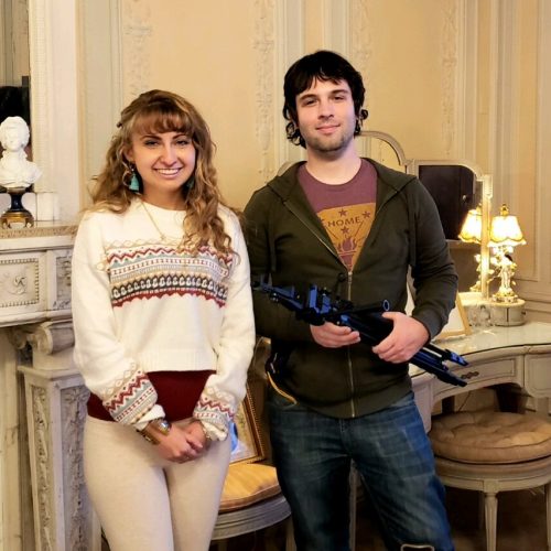 Woman and Man holding filming equipment in mansion