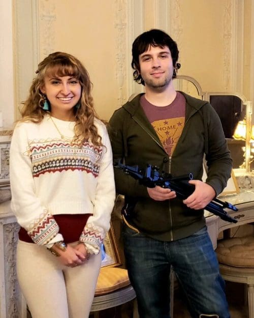 Woman and Man holding filming equipment in mansion