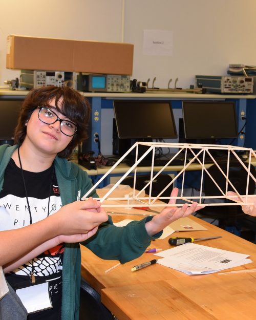 Ayden Wollweber, Vivianna Ruiz and Timothy Pierce display their wooden bridge project created at the high school camp in 2019.