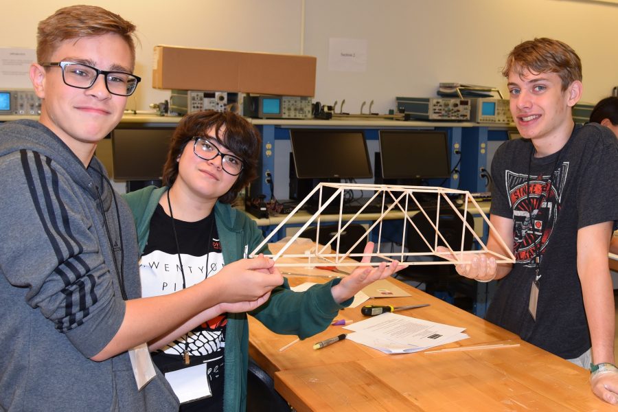 Ayden Wollweber, Vivianna Ruiz and Timothy Pierce display their wooden bridge project created at the high school camp in 2019.