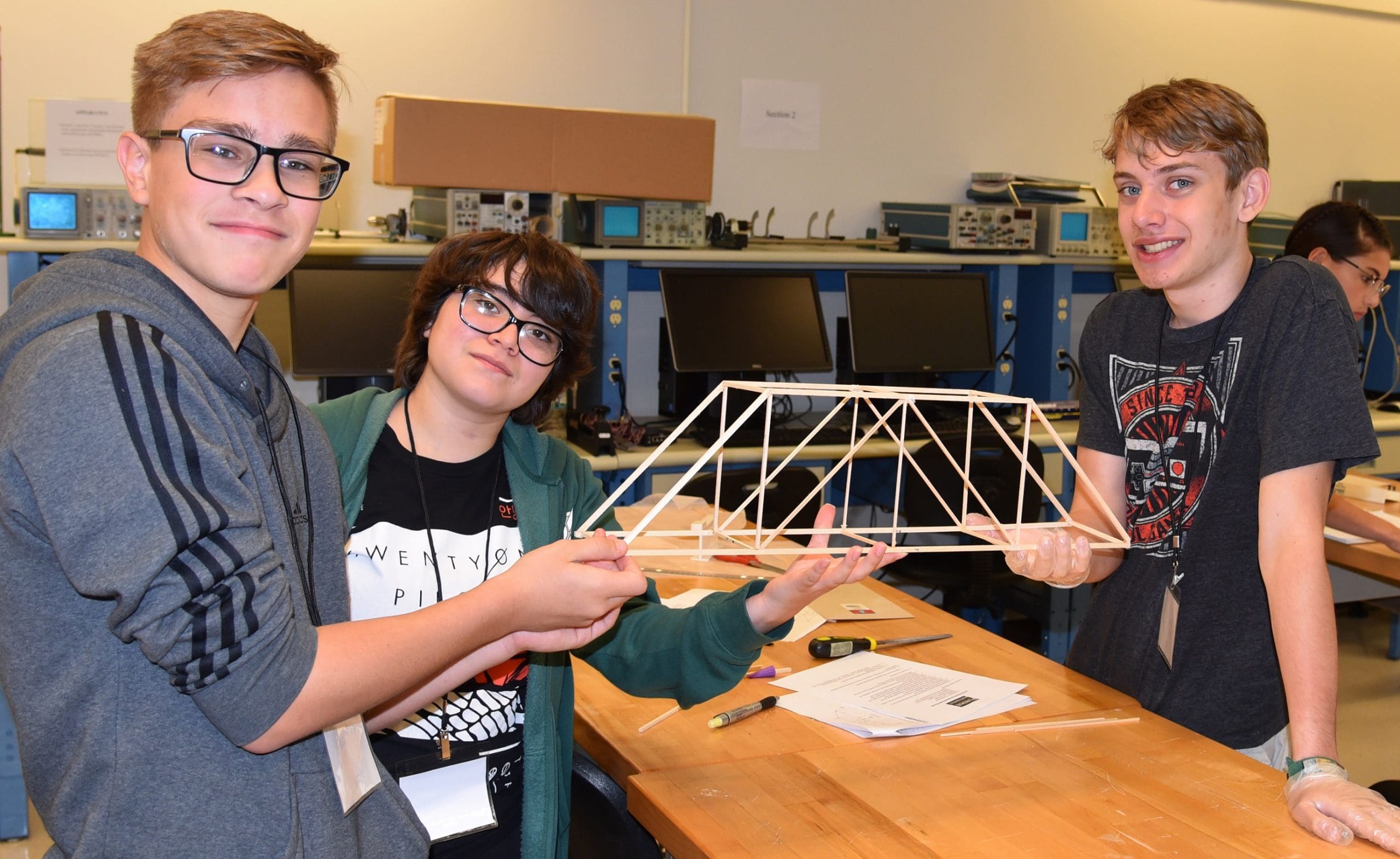 Ayden Wollweber, Vivianna Ruiz and Timothy Pierce display their wooden bridge project created at the high school camp in 2019.