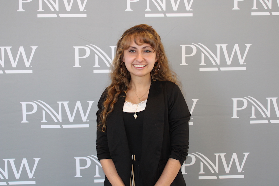 Kayla posing in front of PNW backdrop.