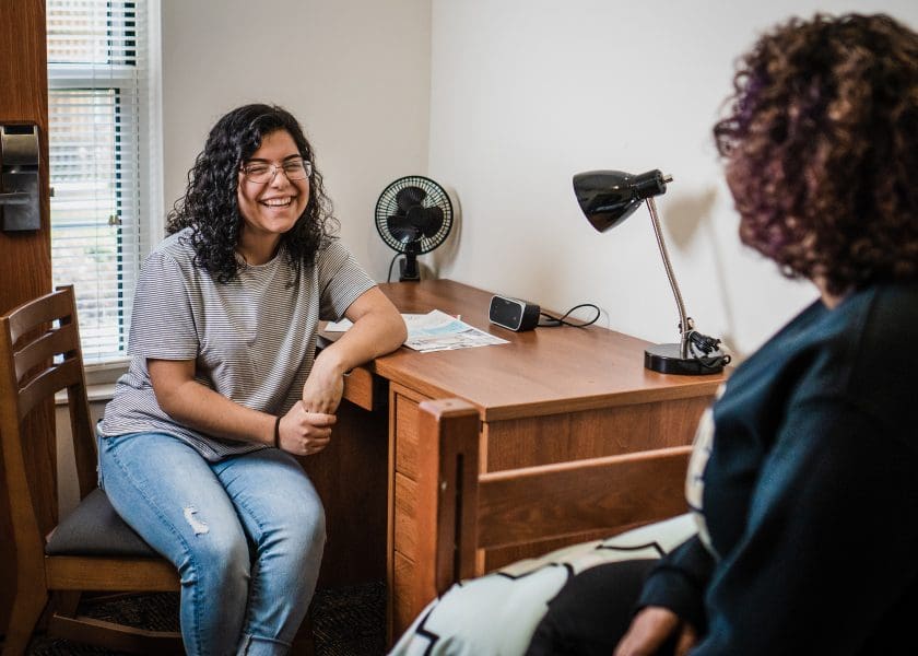 A PNW student sits at her desk in university housing