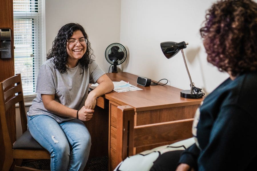 A PNW student sits at her desk in university housing