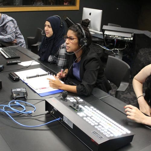 PNW broadcast students sit at the production table