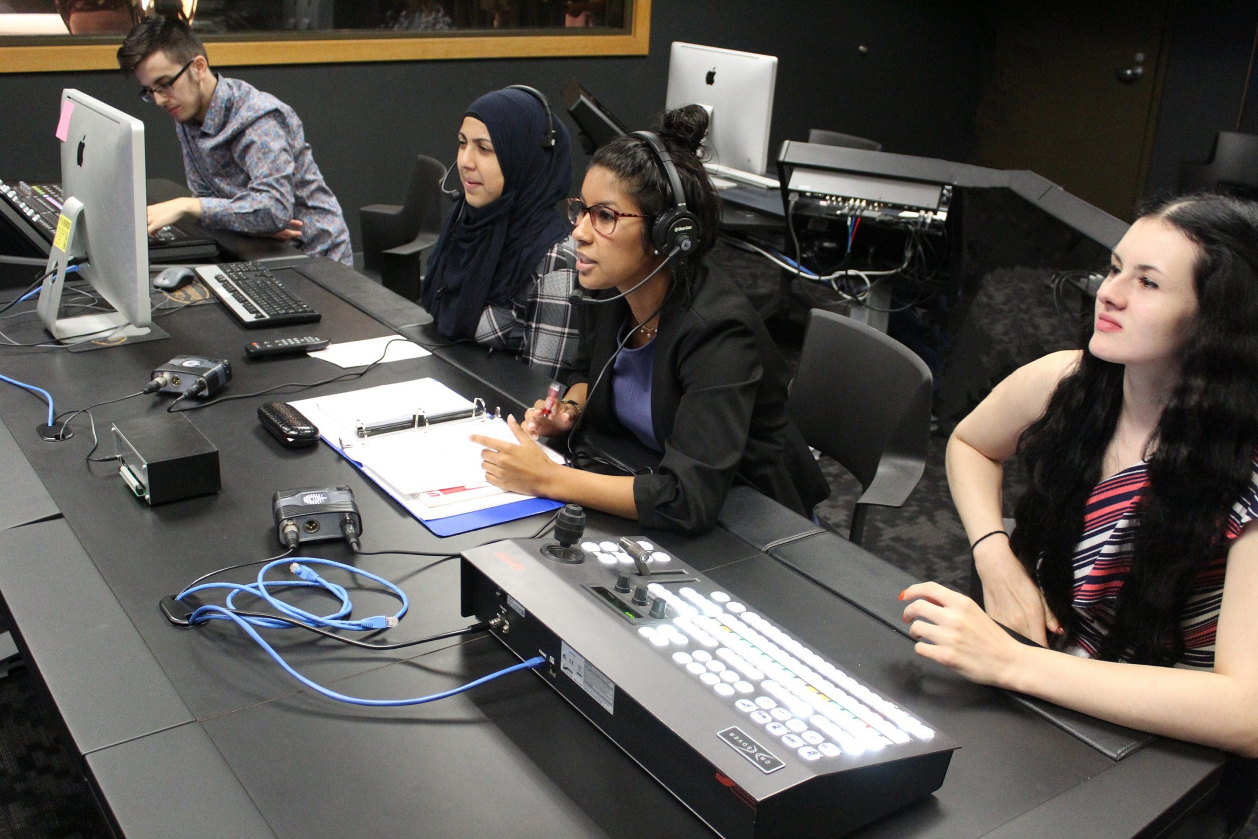 PNW broadcast students sit at the production table