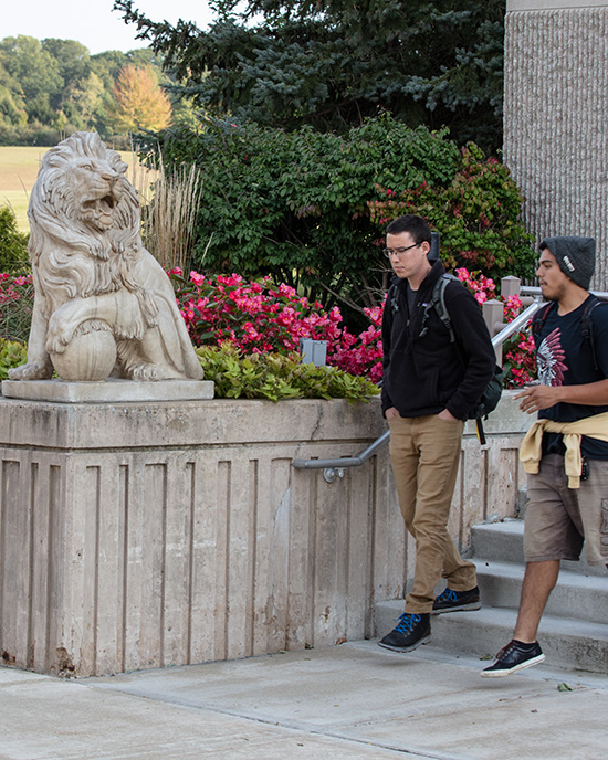 Students walk near a lion sculpture on PNW's Westville Campus