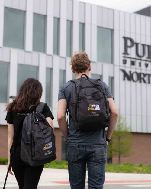 Two PNW students stand with their backs visible in front of the Nils K. Nelson Bioscience Innovation Building