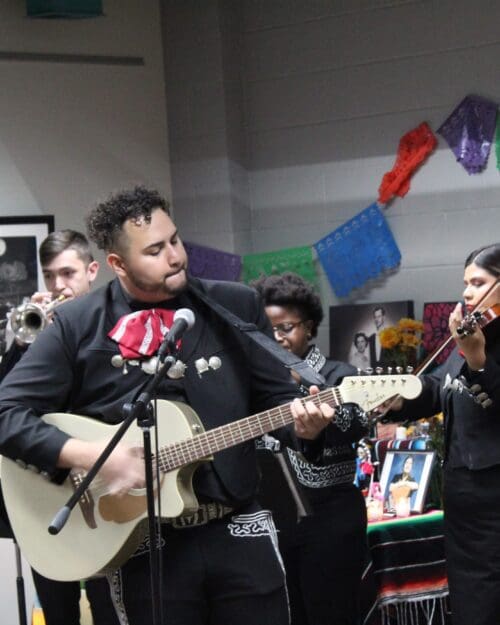 A man in a band plays guitar