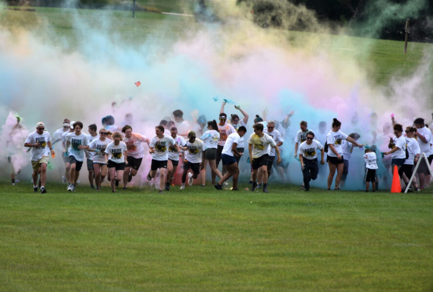 Runners covered in color powder as racers start the PNW Pride Stride