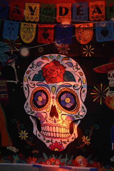 Colorful artwork sets the backdrop for a Dia de los Muertos celebration.