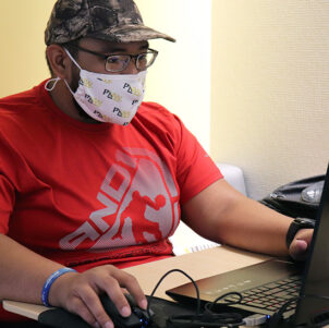 A masked PNW student studies in the Nils K. Nelson Bioscience Innovation Building