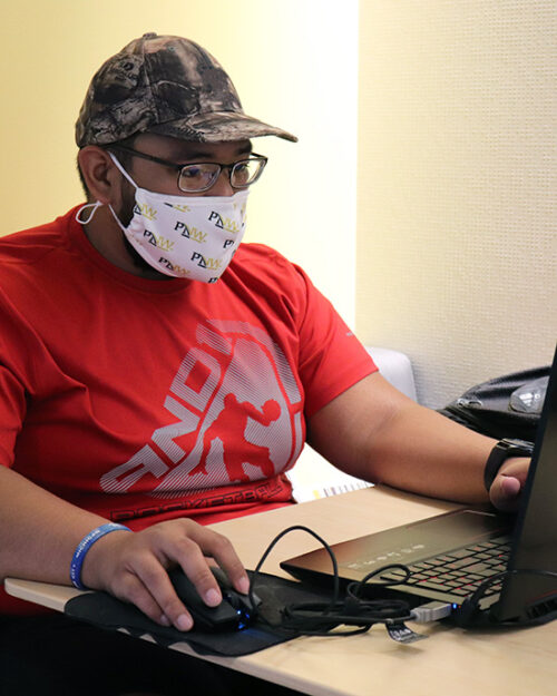 A masked PNW student studies in the Nils K. Nelson Bioscience Innovation Building