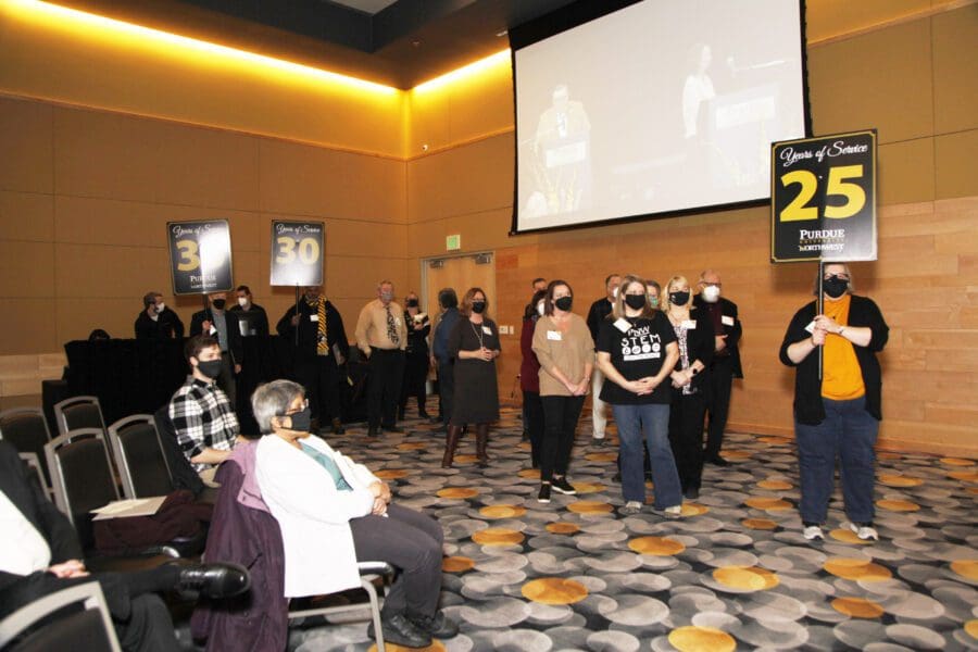 Various PNW staff and faculty crowd together, according to their years of service.