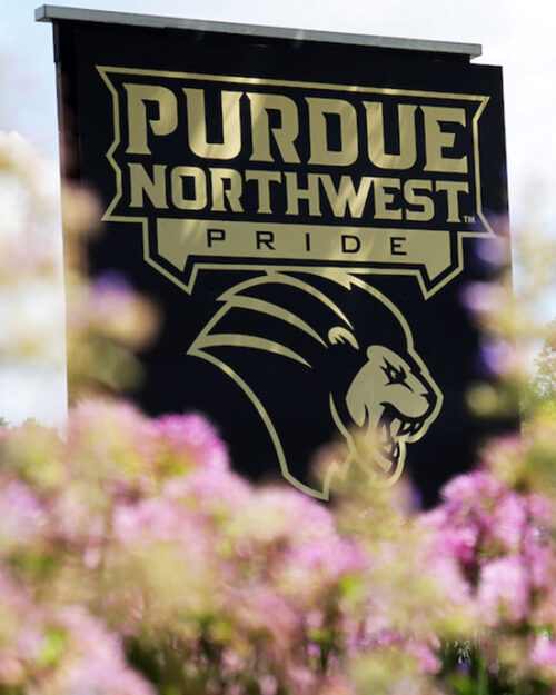 A Purdue Northwest Pride sign surrounded by flowers