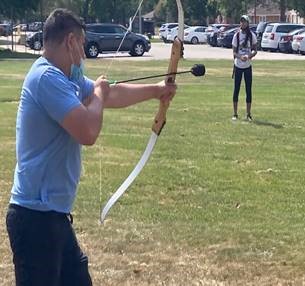 A member of the PNW community lines up a shot with a foam bow and arrow.