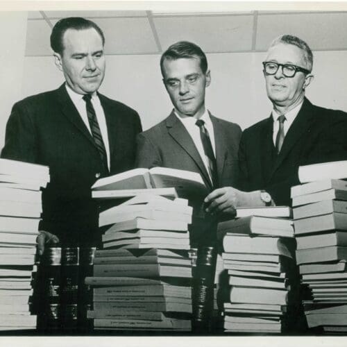 In 1964, the Chicago District Council of the American Society for Testing and Materials (ASTM) donated technical literature, valued at approximately $500, to the library at the Calumet campus. This picture was taken to accompany its news release. Pictured left to right are Dr. Carl Elliott, then director of the Calumet campus, Charles H. Hutton, head of the Architectural and Civil Engineering Department, and an unidentified man.