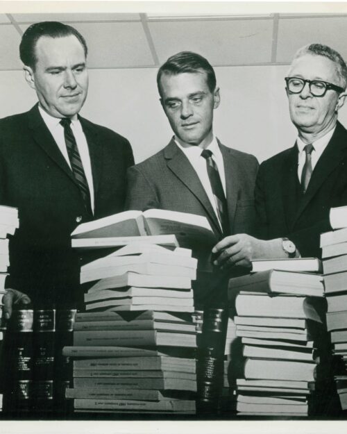 In 1964, the Chicago District Council of the American Society for Testing and Materials (ASTM) donated technical literature, valued at approximately $500, to the library at the Calumet campus. This picture was taken to accompany its news release. Pictured left to right are Dr. Carl Elliott, then director of the Calumet campus, Charles H. Hutton, head of the Architectural and Civil Engineering Department, and an unidentified man.