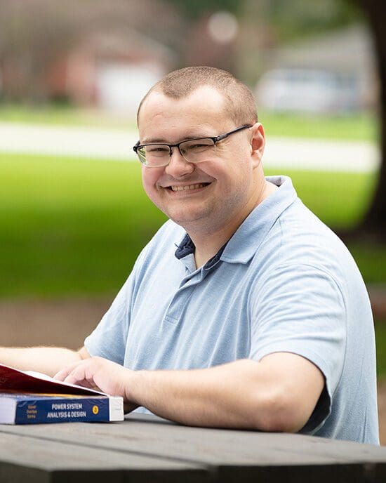 A PNW student studies outdoors at a picnic table
