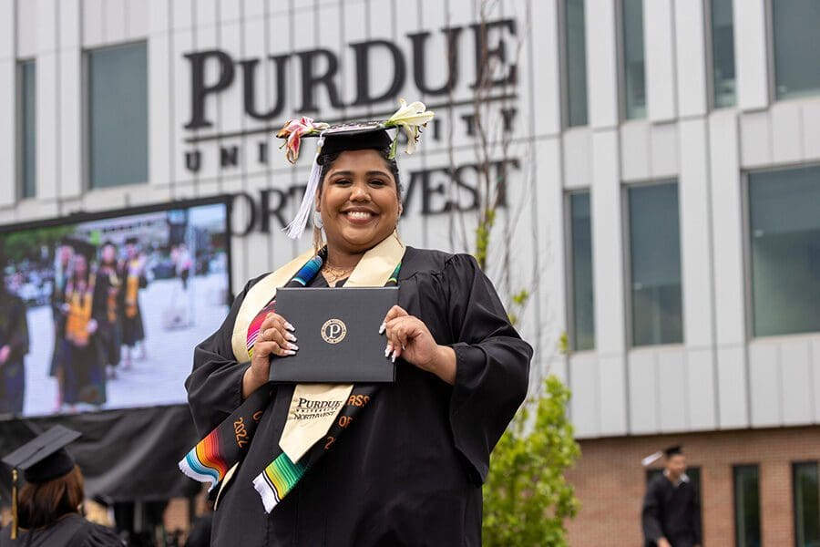 A PNW graduate poses with her diploma