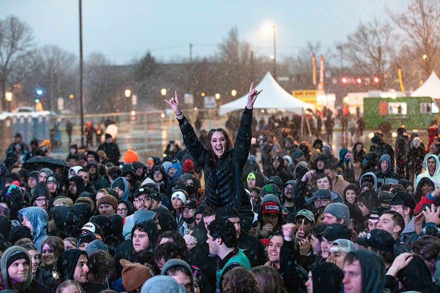 Crowd of students with one student on another student's shoulders to be above the crowd