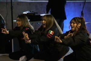 Three students dancing on stage