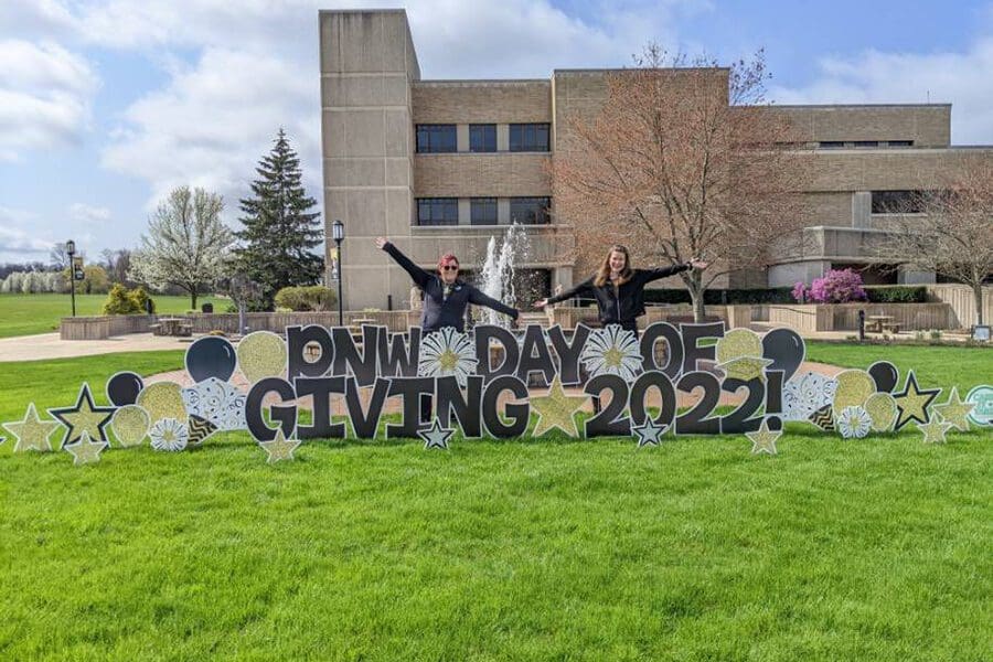 PNW students pose near a PNW Day of Giving 2022 Yard Sign