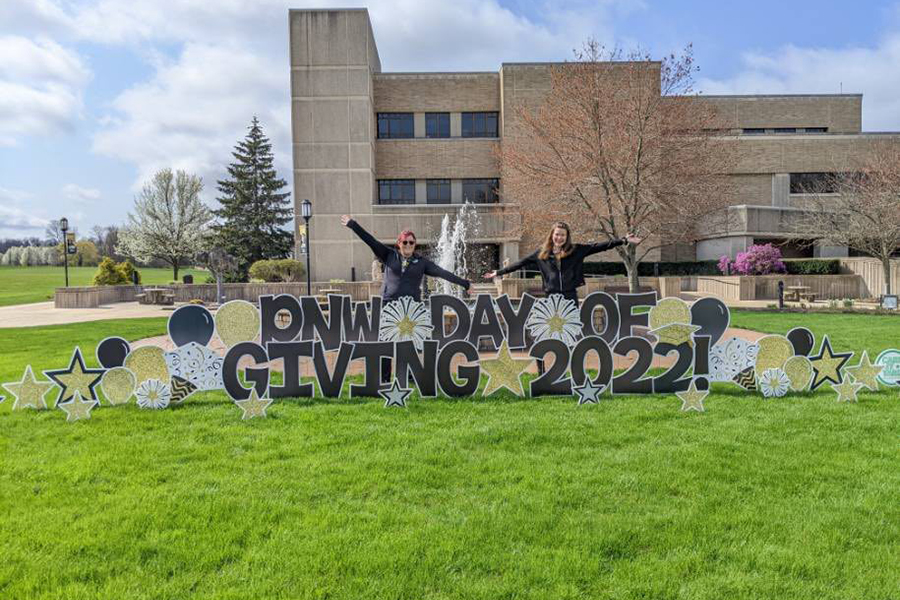 PNW students pose near a PNW Day of Giving 2022 Yard Sign
