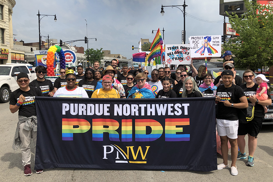 Students, faculty and staff marching behind a "Purdue Northwest Pride" banner during the Chicago Pride Parade