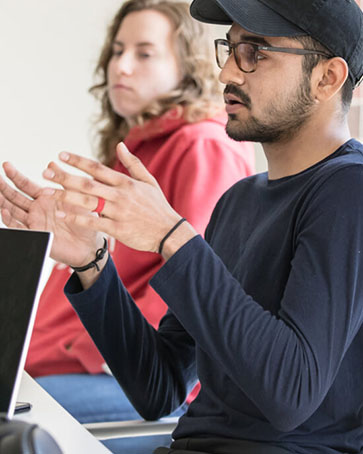 student in hat sitting in class