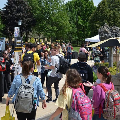 Students walk around, vising tables during a welcome rally