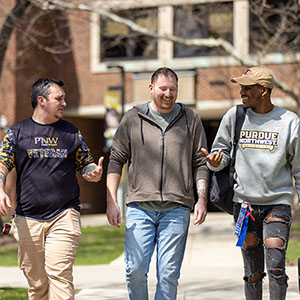 Three PNW students walk on a sidewalk
