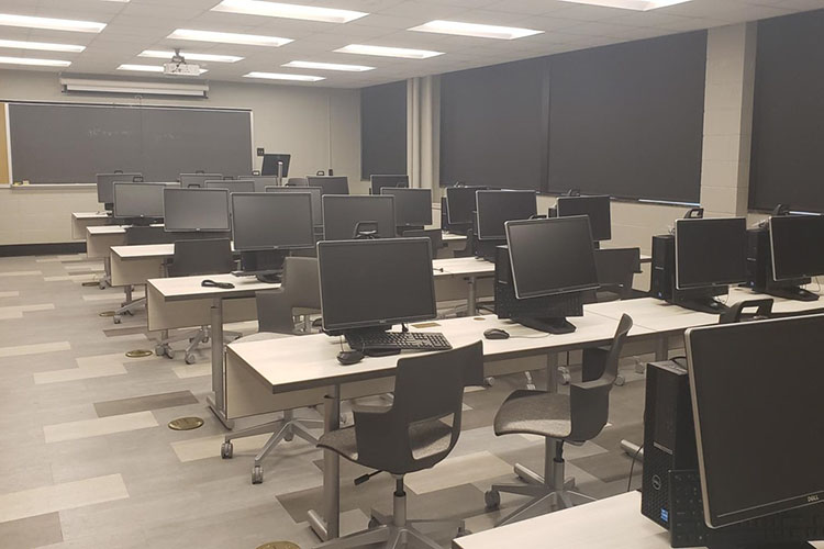 A classroom with computers and a blackboard