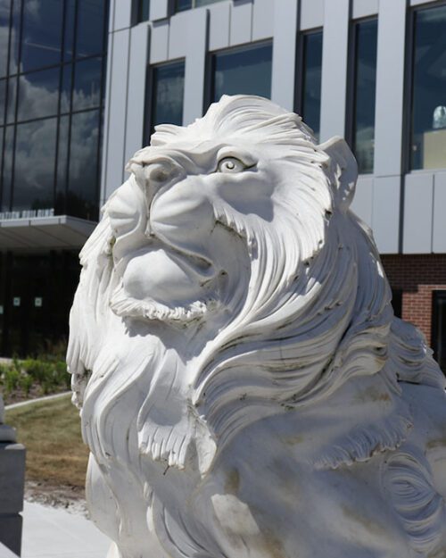 A lion sculpture in front of the Nils K Nelson Bioscience Innovation Building