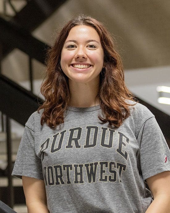 A PNW student poses in the Student Union and Library Building