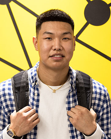 A PNW student poses in front of a painting