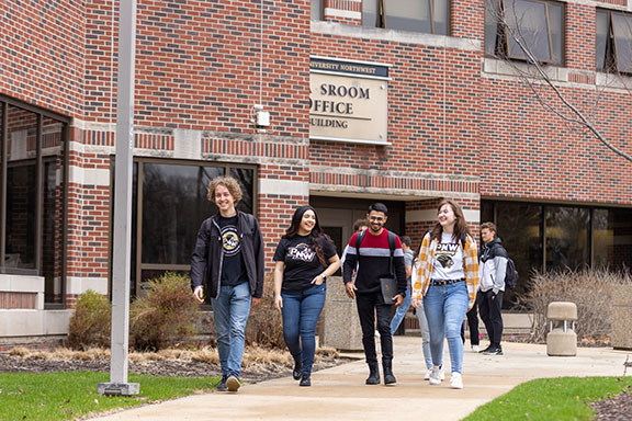 Four students walk together outside